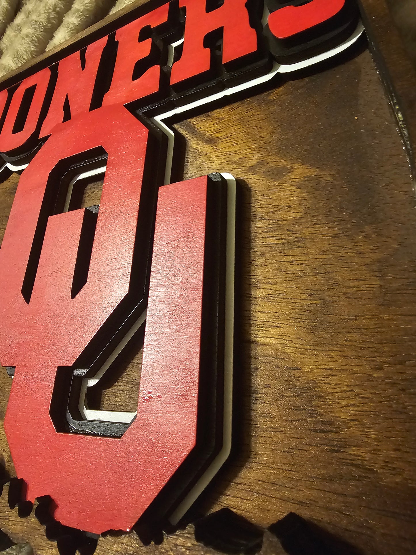 Layered wood sports sign with bold red 'Sooners' lettering, custom crafted by BearNugget Customs