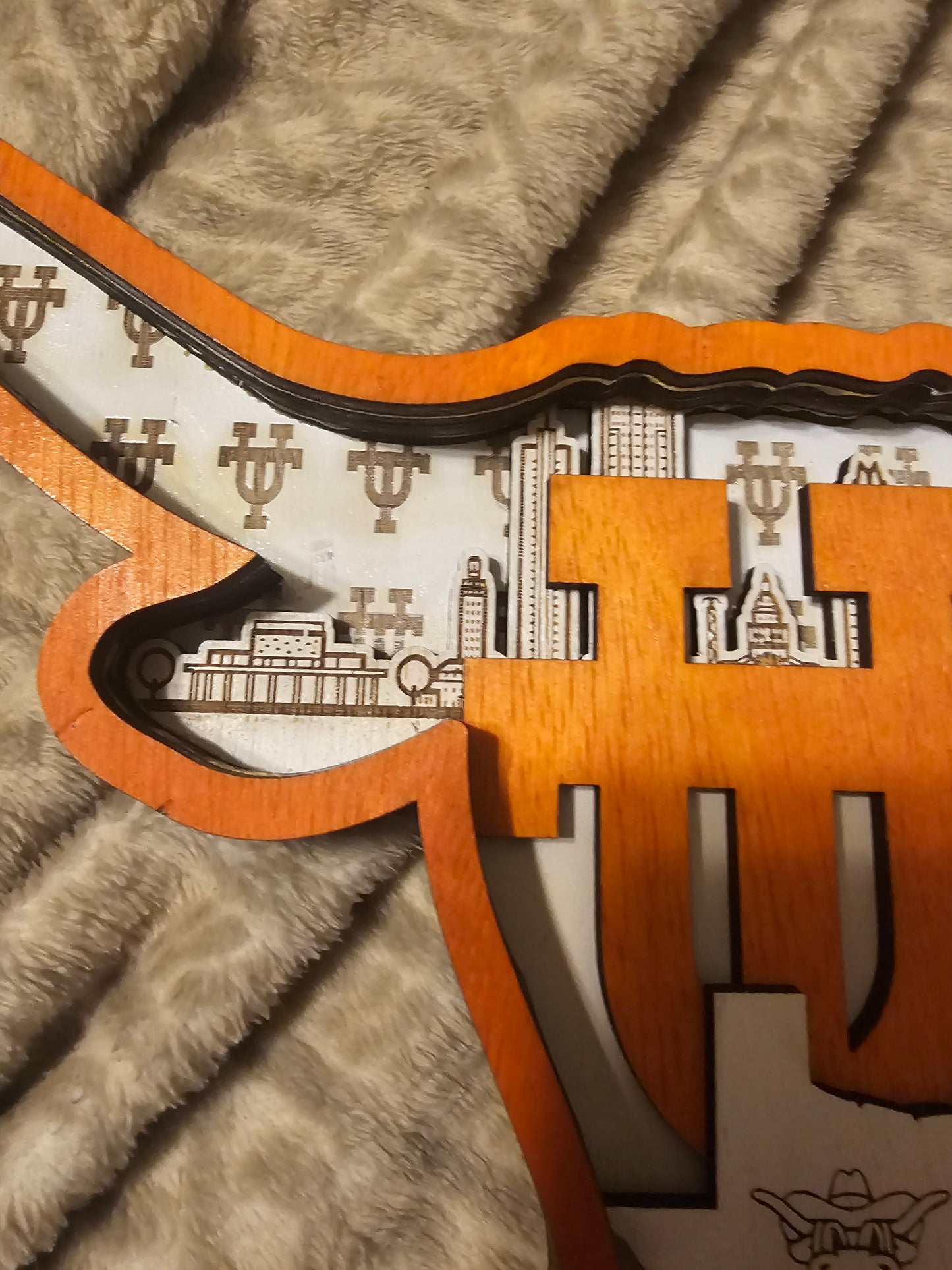 Custom wooden Texas Longhorn wall sign with cityscape design by Bearnugget Customs on blanket