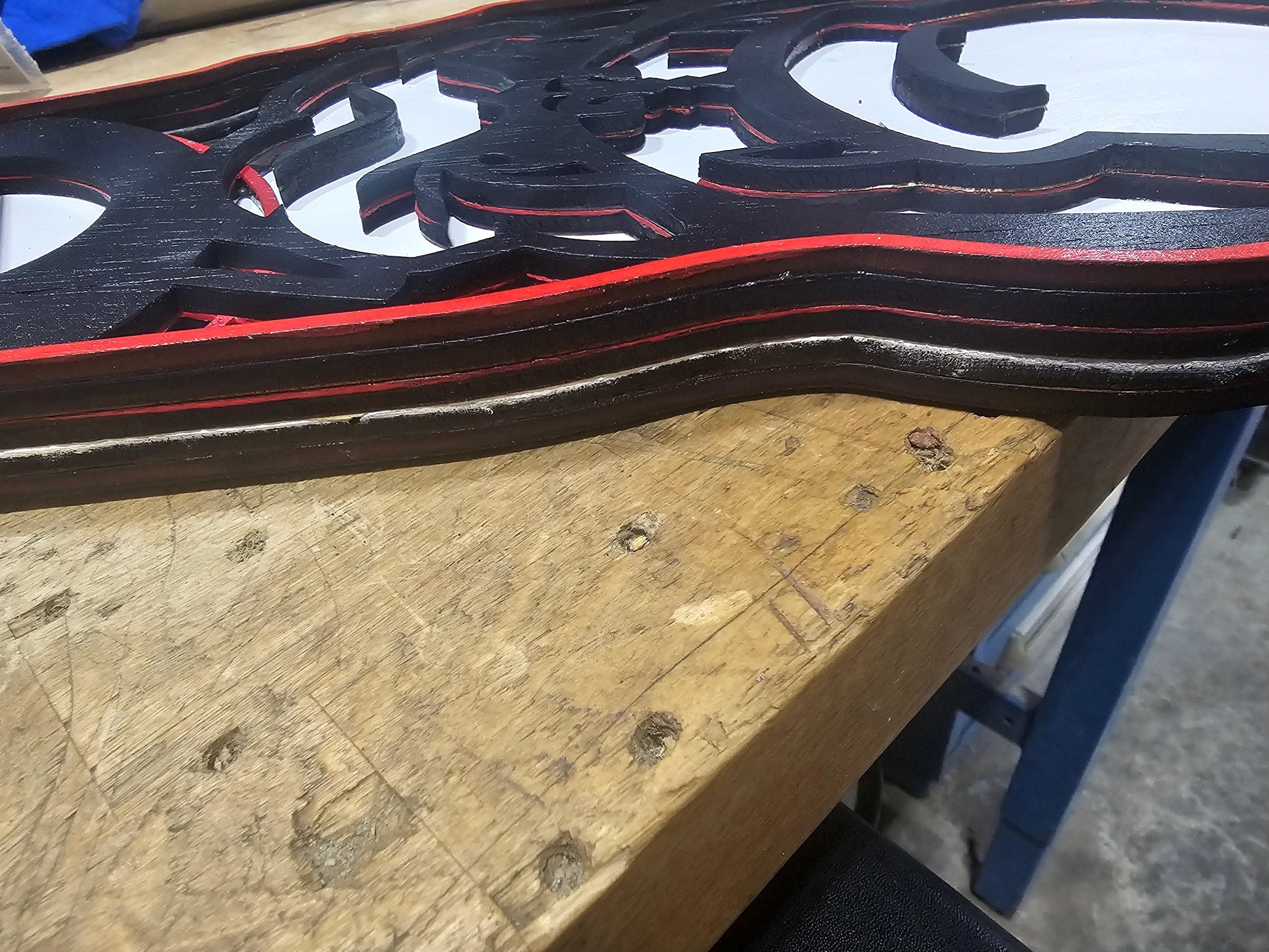 Layered custom wood sports sign with black and red edges on a workbench, BearNugget Customs