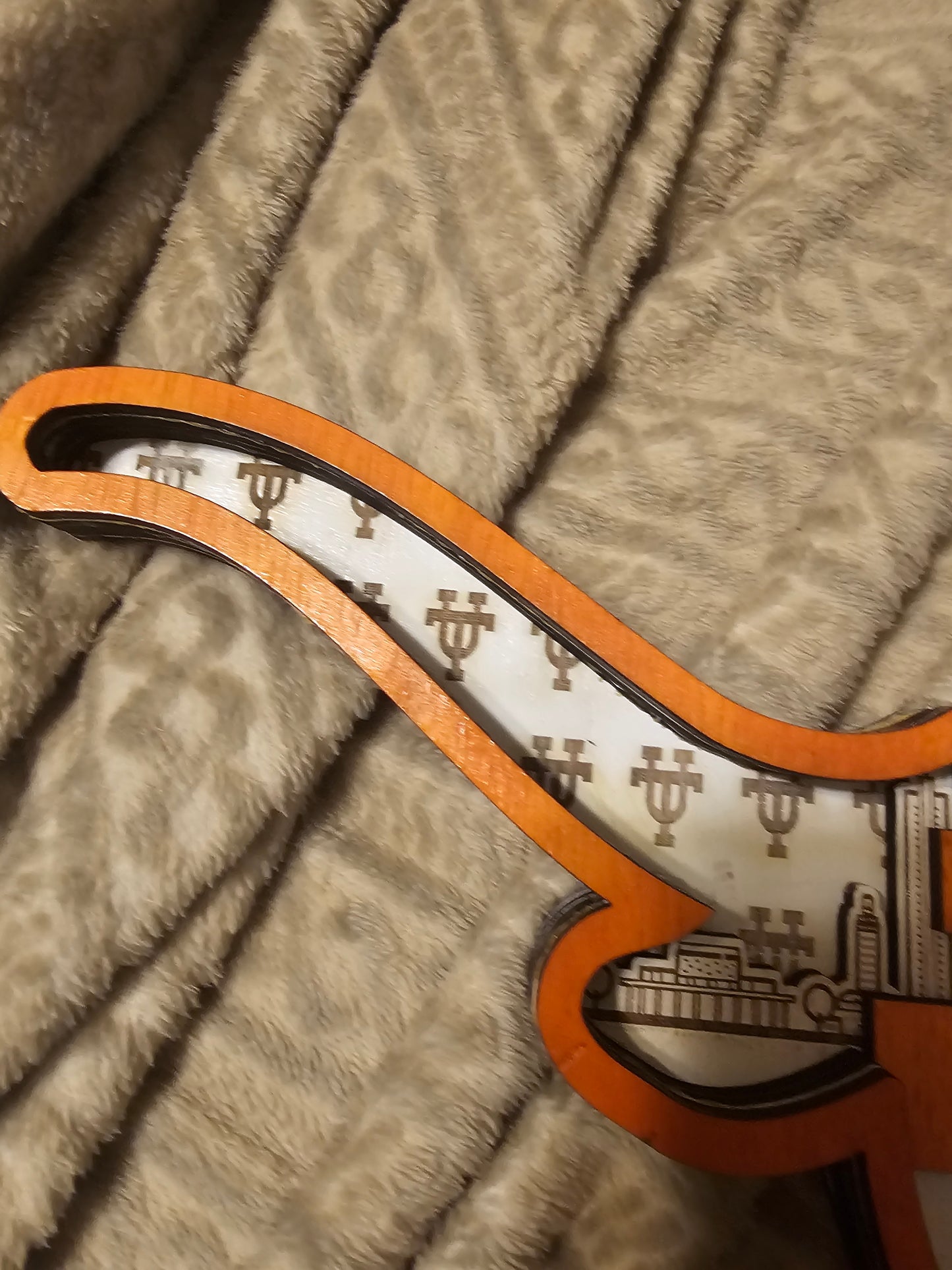 Custom wooden sports sign detail with IU logos on a beige patterned blanket, Bearnugget Customs