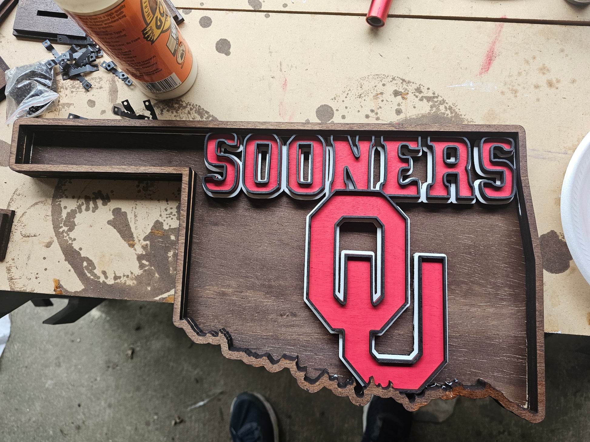 Handcrafted Oklahoma Sooners sign in state shape by BearNugget Customs on workbench
